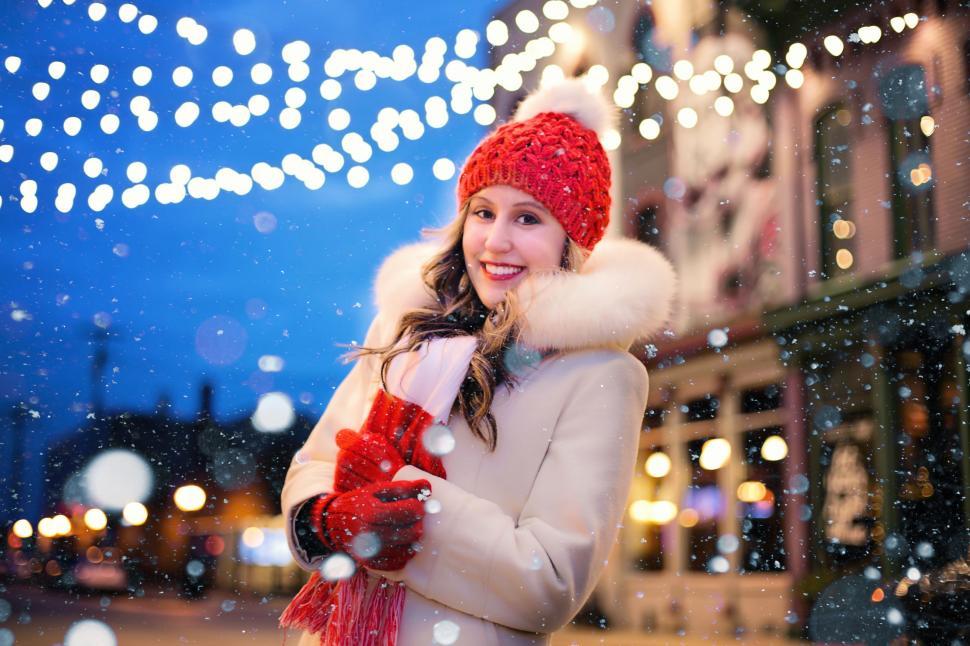 Free Image of Smiling Woman In Red Knitted Hat With Xmas Snow - Looking at camera 