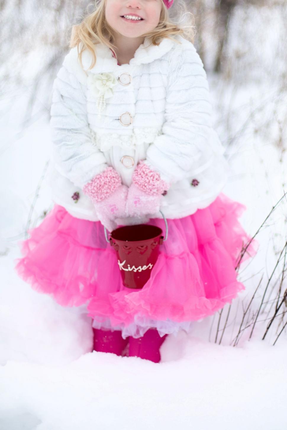 Free Image of Little Girl with tiny red bucket in snow 