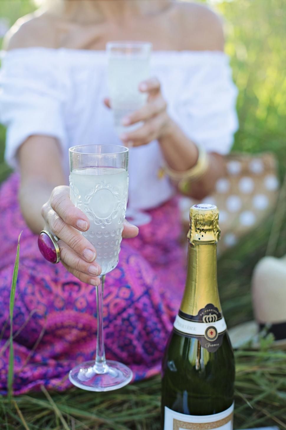 Free Image of Woman With Wine Bottle and Glass on Green Grass 