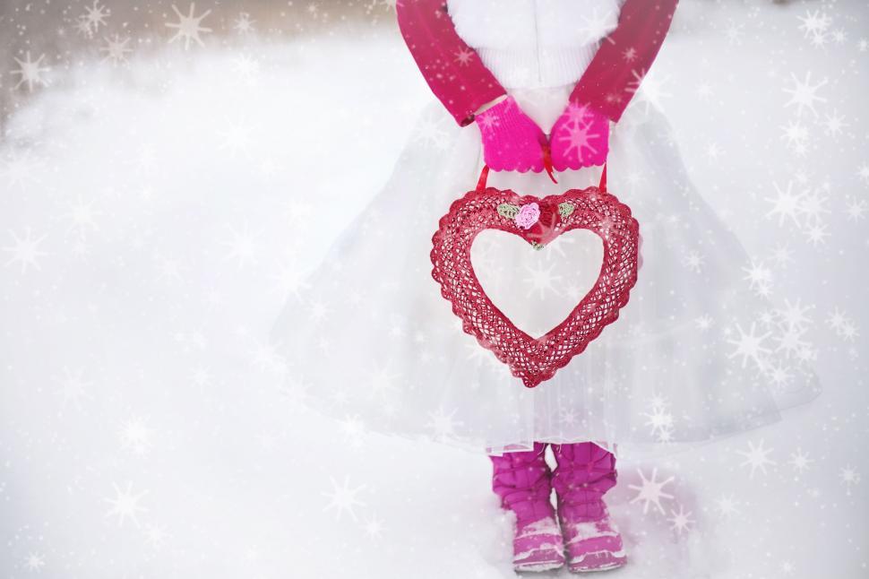 Free Image of Girl Holding Red Heart in Snowfall  