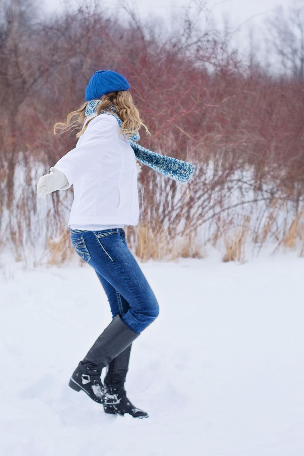 Free Image of Young Woman in Blue Cap Enjoying Snow With Trees 