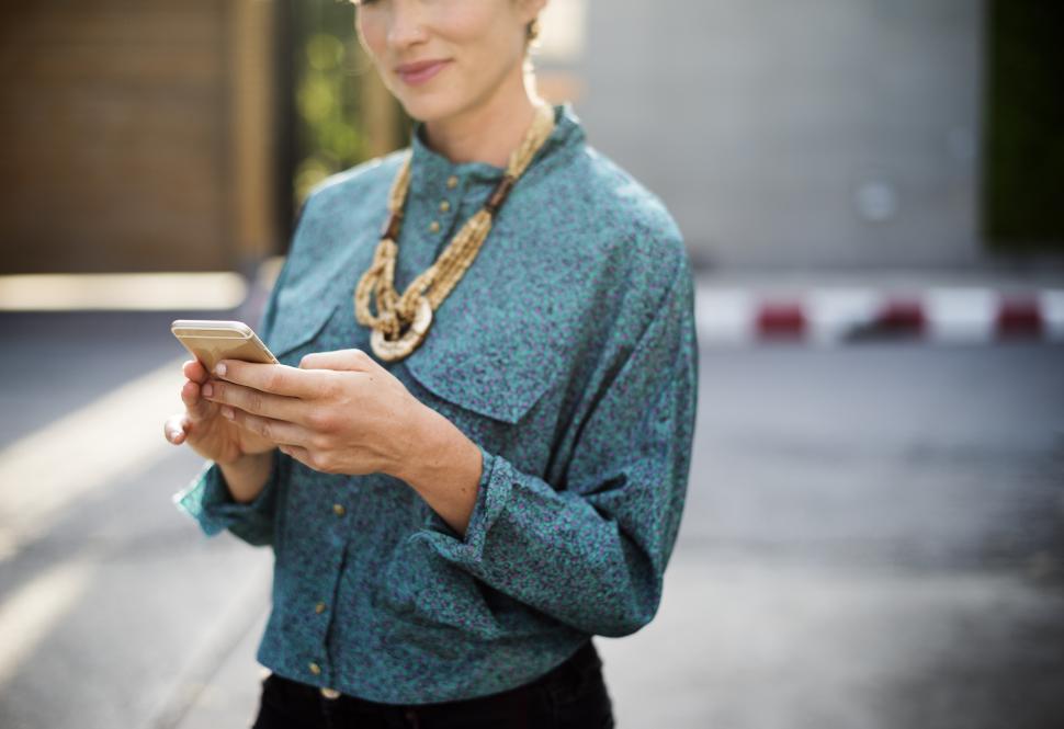 Free Image of A stylish young woman looking at her mobile phone 