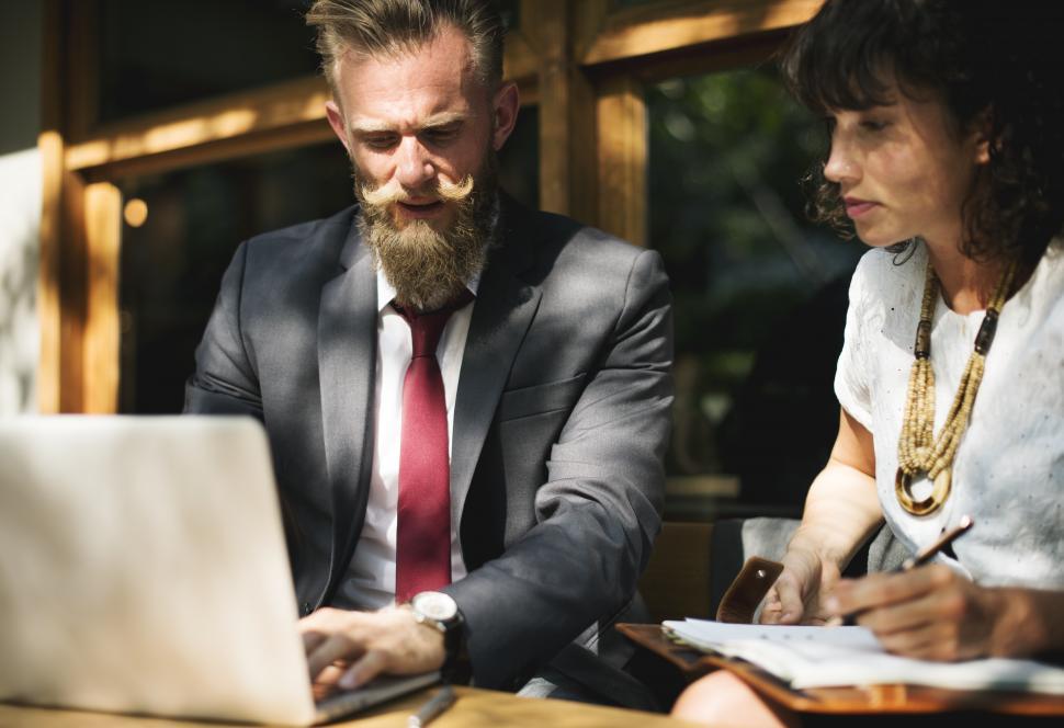 Free Image of Scene of two business people discussing at an outdoor restaurant table 