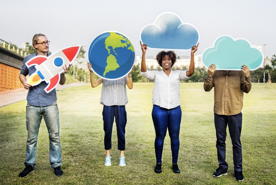 Free Image of A group of volunteers posing with a globe, a rocket and cloud shaped cardboard cutouts 