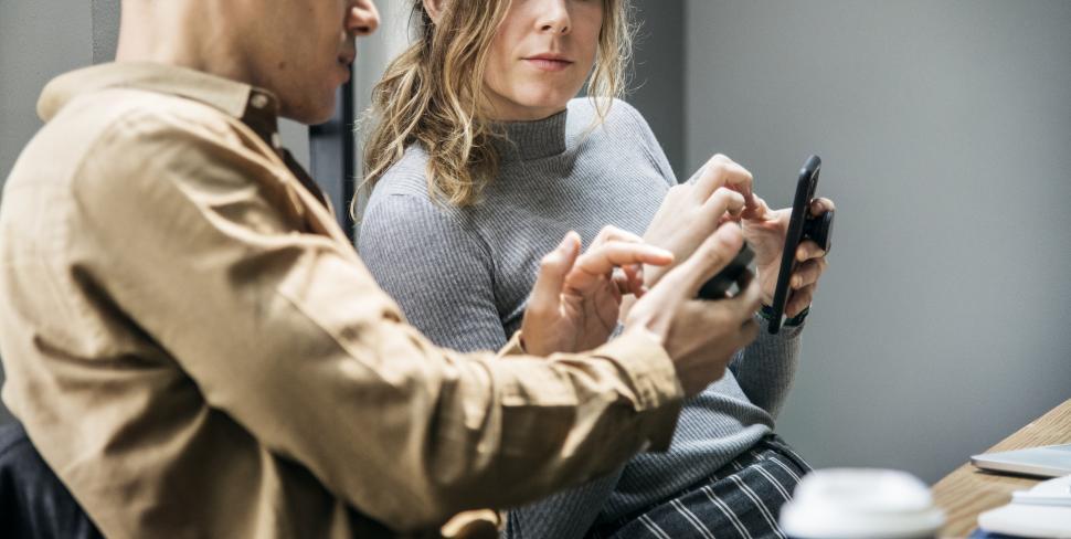 Free Image of Two colleagues in the office working on mobile devices 