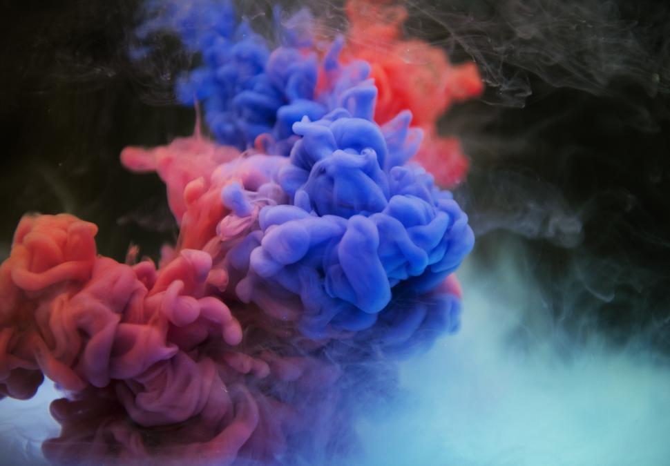 Free Image of An abstract smokey pattern of red and blue ink swirling in water 