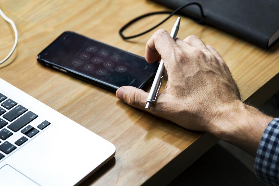 Free Image of Close up of a person s hand picking a mobile phone 