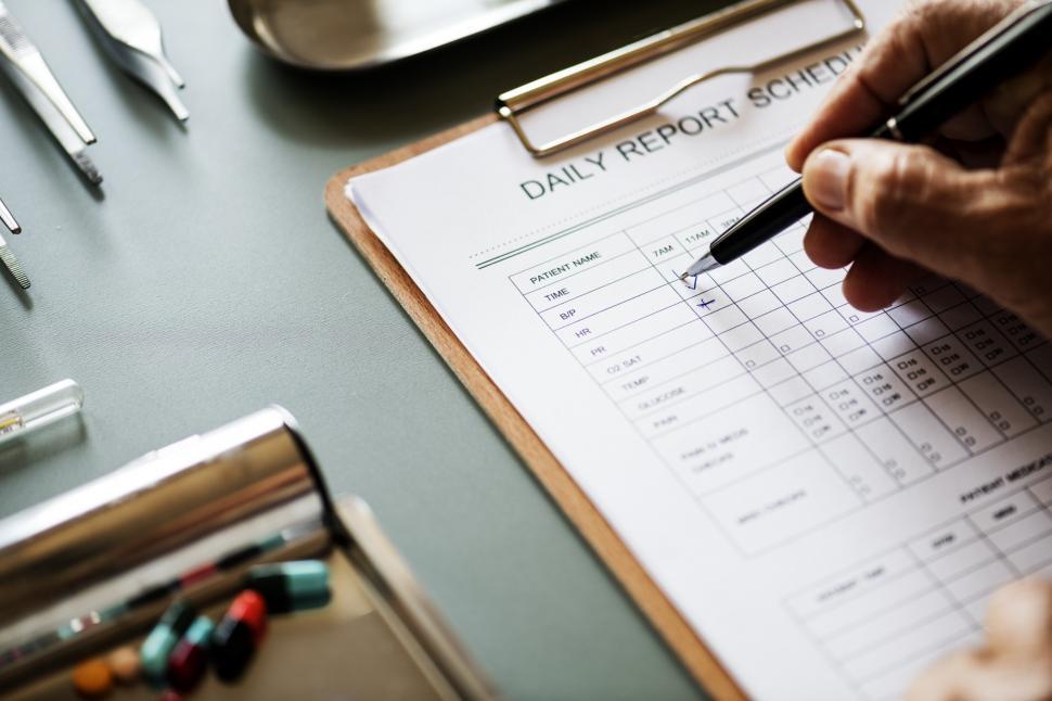 Free Image of Close up of a doctor hand checking schedule report 