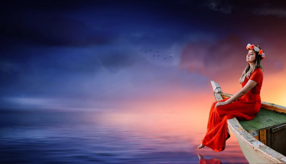Free Image of Woman with flower wreath on boat with colorful clouds 