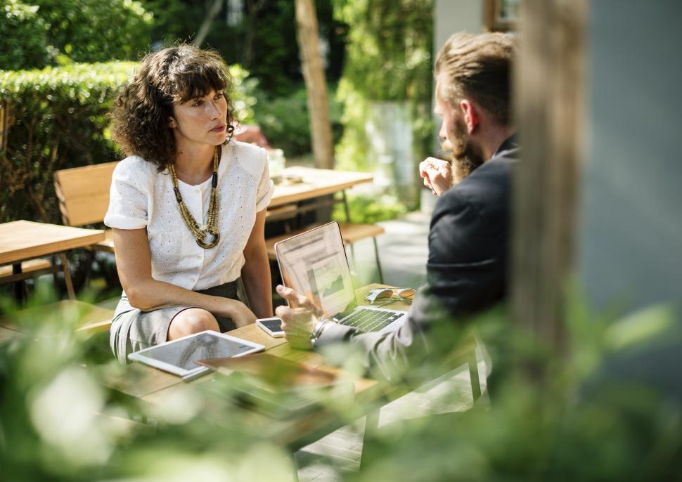 Free Image of View of two people talking at an outdoor restaurant table 