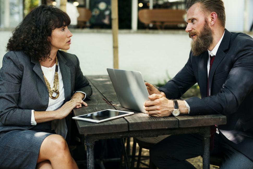 Free Image of People discussing at an outdoor restaurant table with business tech 