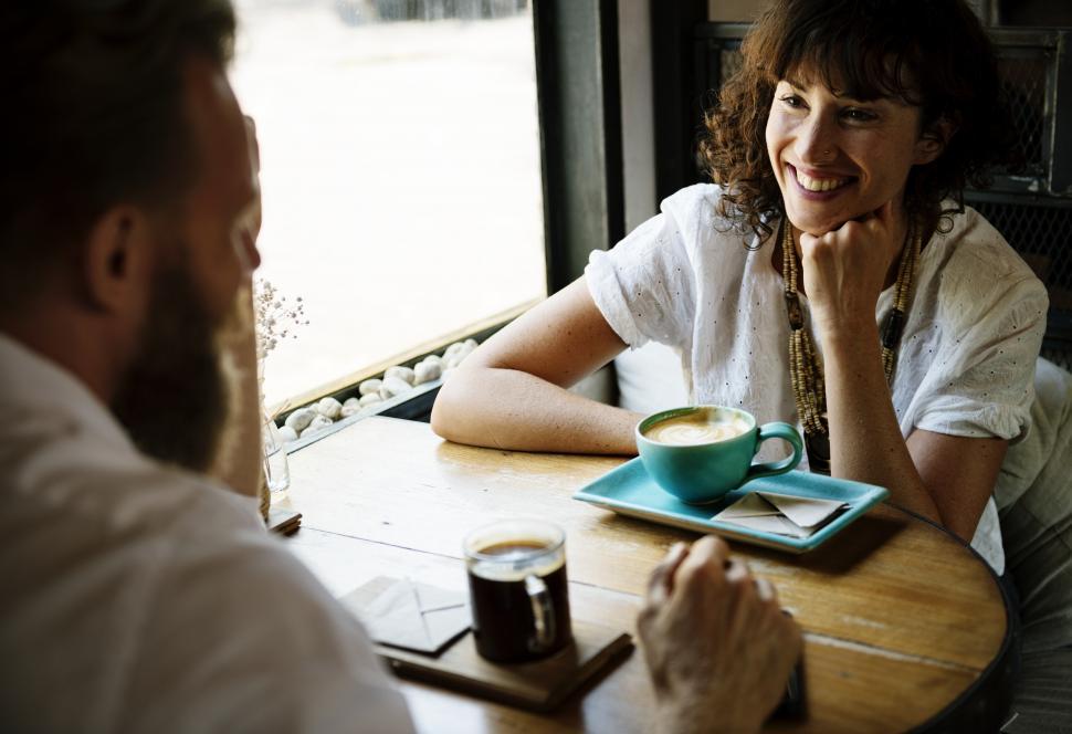 Free Image of Friendly people discussing at a restaurant table 