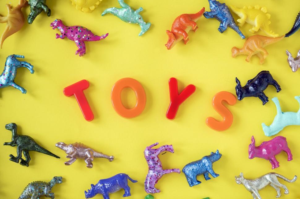 Free Image of Text - TOYS surrounded with colorful toy animals on yellow surface 