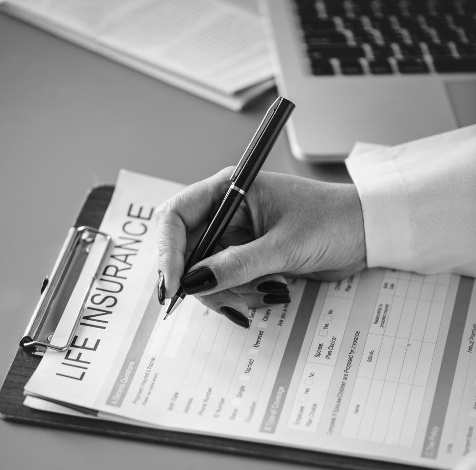 Free Image of Close up of a doctor s hand writing on the insurance questionnaire 