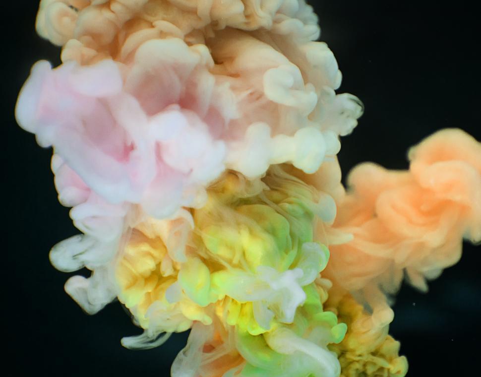 Free Image of An abstract pattern of yellow, pink and orange ink swirling in water 