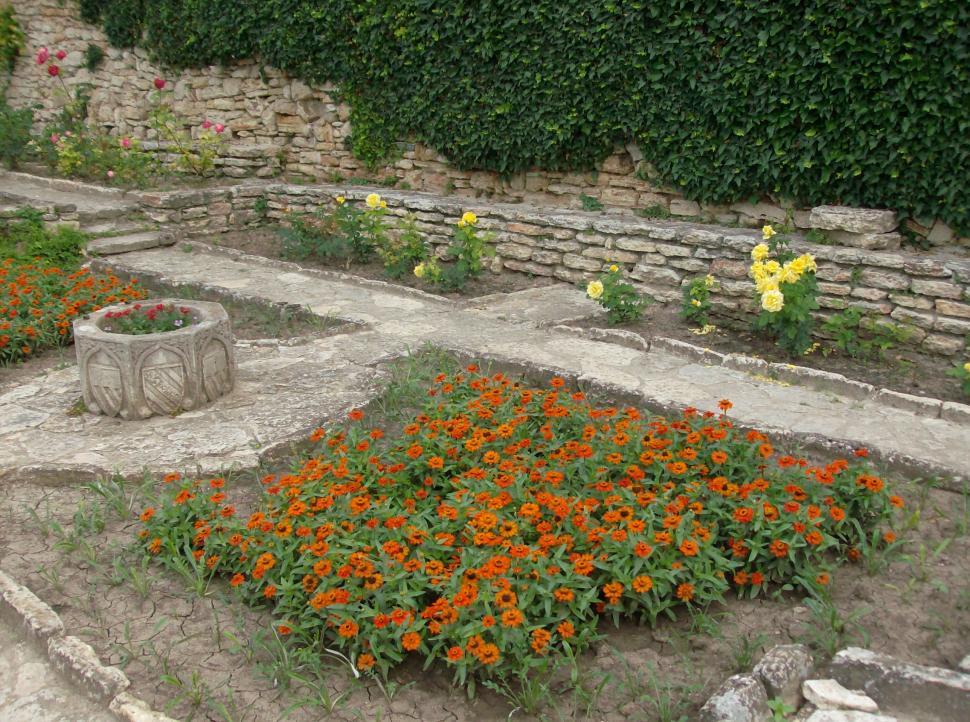 Free Image of Small garden full with flowers and stone alleys 