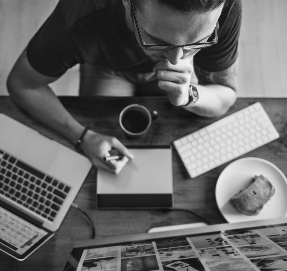 Free Image of Black and white cverhead view of a man working on digital drawing pad 