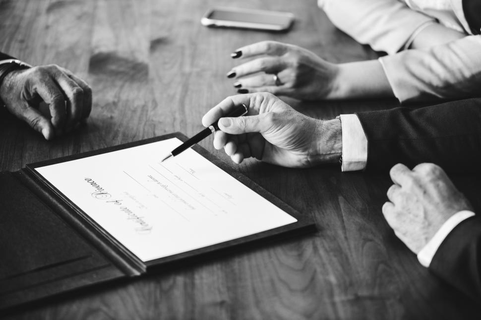 Free Image of Black and white photo of hand signing on the divorce certificate 