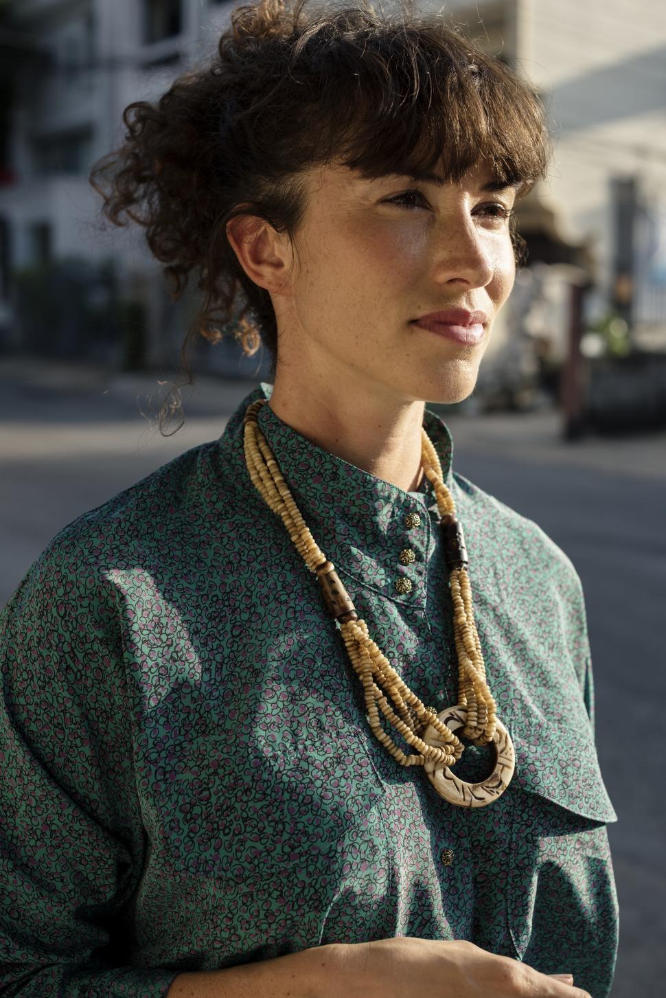 Free Image of A young woman dressed professionally, standing outdoors 