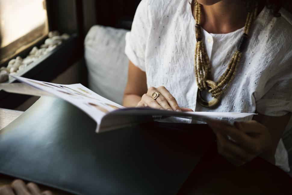 Free Image of A young woman reading menu at a restaurant table 