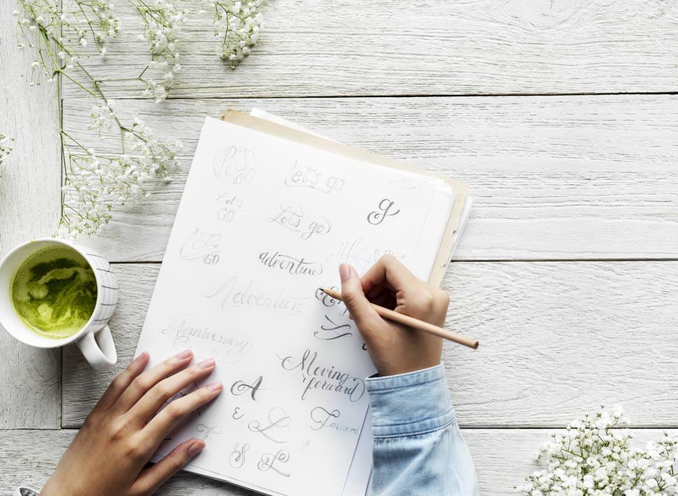 Free Image of Over head view of a hand practicing calligraphy text 