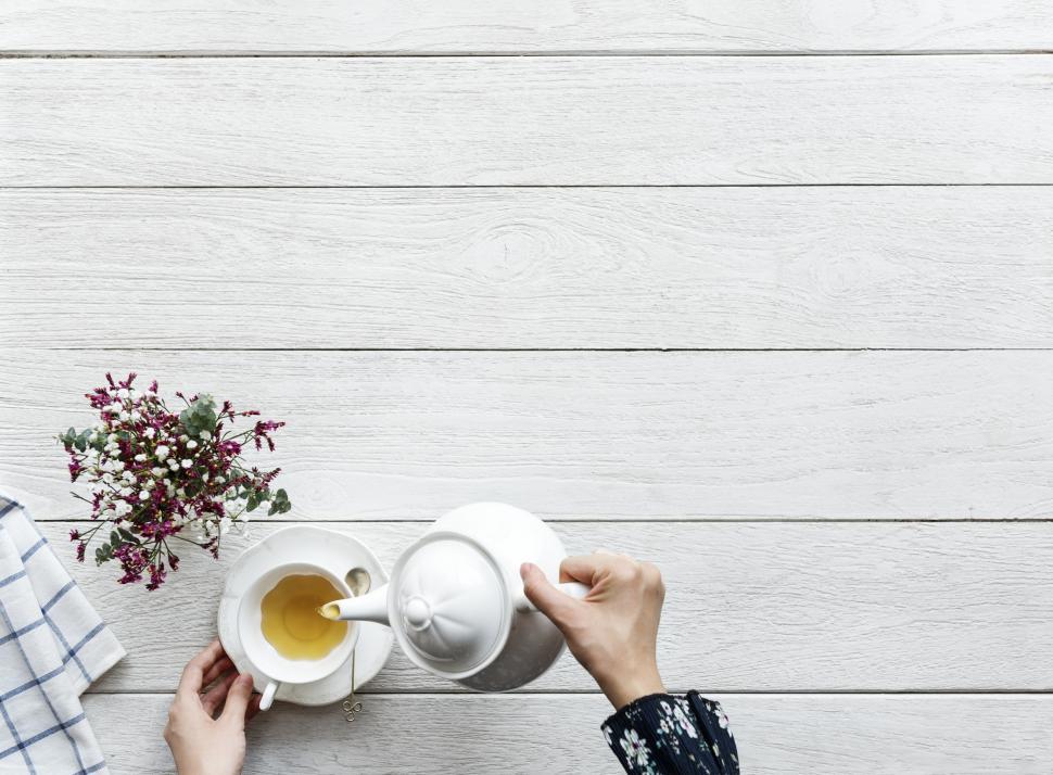 Free Image of Overhead view of a cup of tea alongside a kettle - pouring tea  
