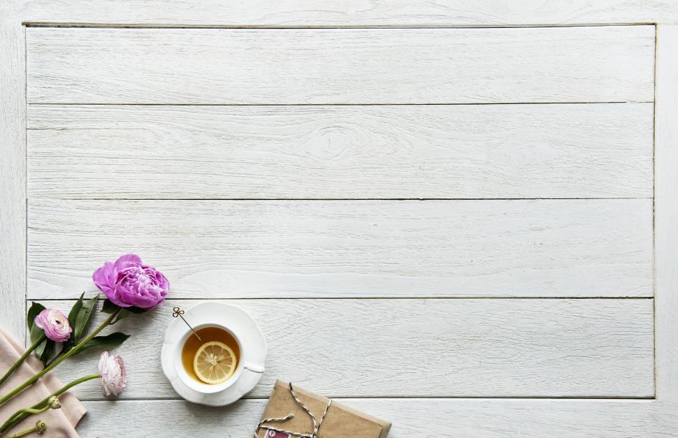 Free Image of Overhead view of a cup of lemon tea alongside a wrapped parcel 