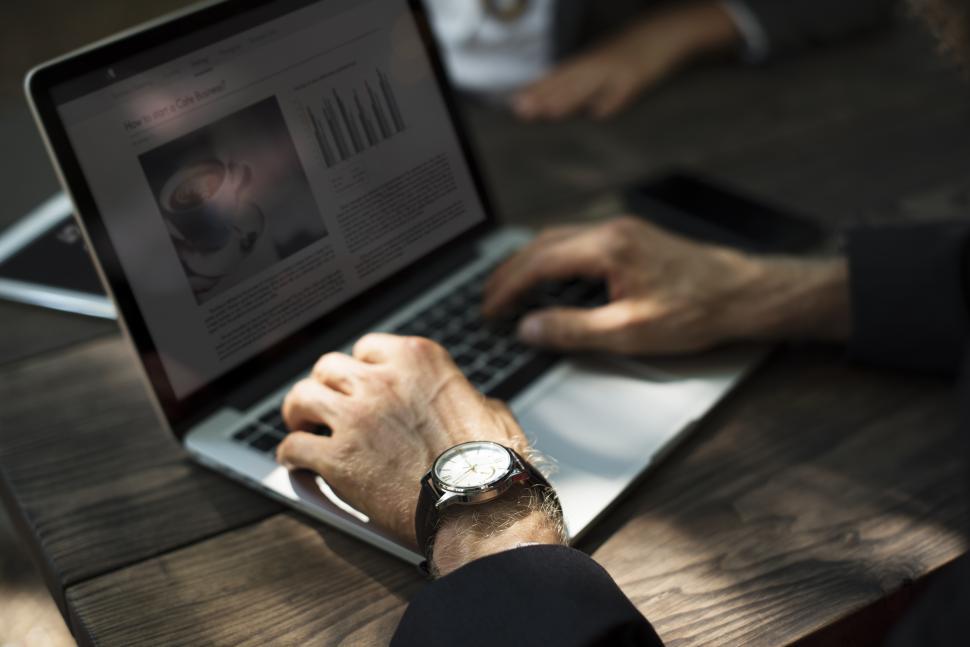 Free Image of Close up of a person in partial sun typing on the laptop 