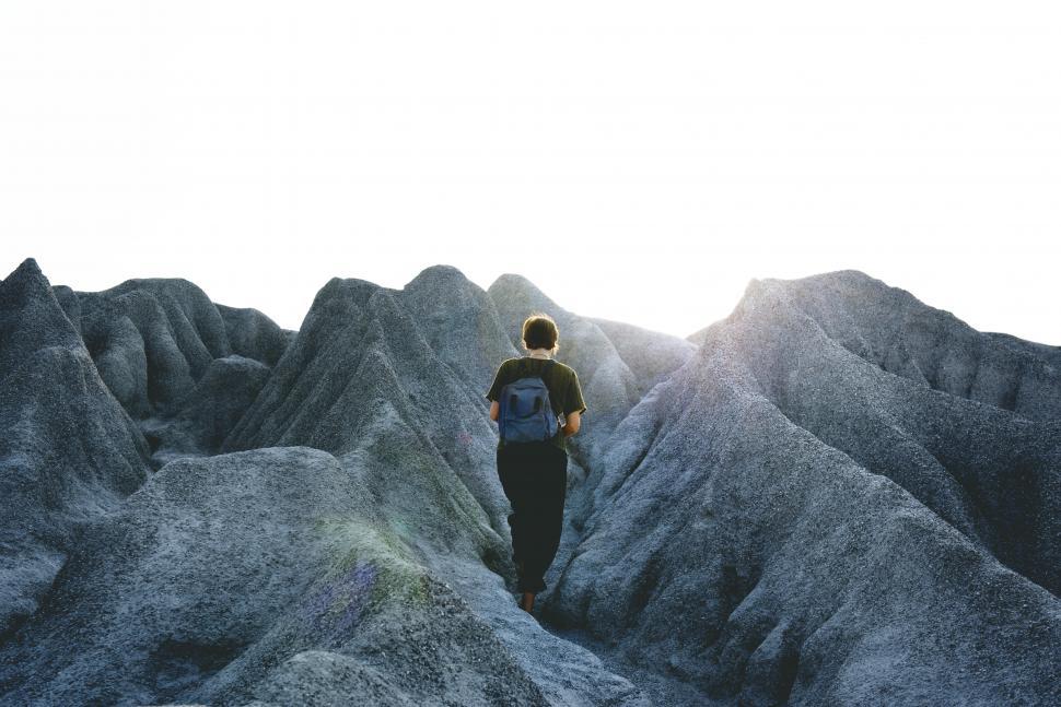 Free Image of A young woman outdoors taking photo on a bumpy hike 