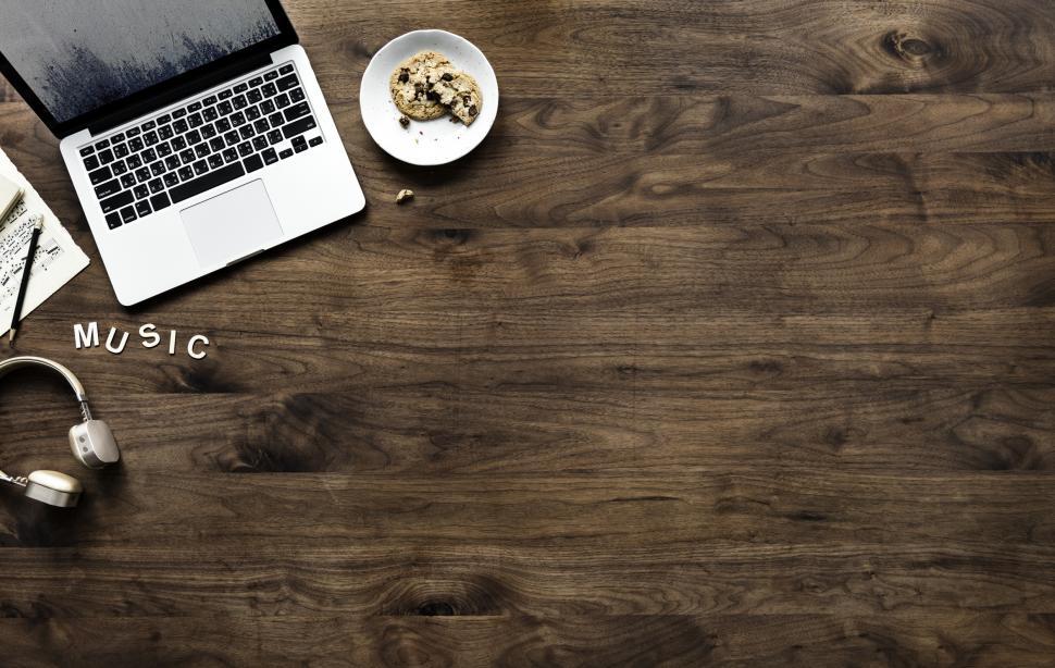 Free Image of Overhead view of a laptop on dark wood table and an audio headset 