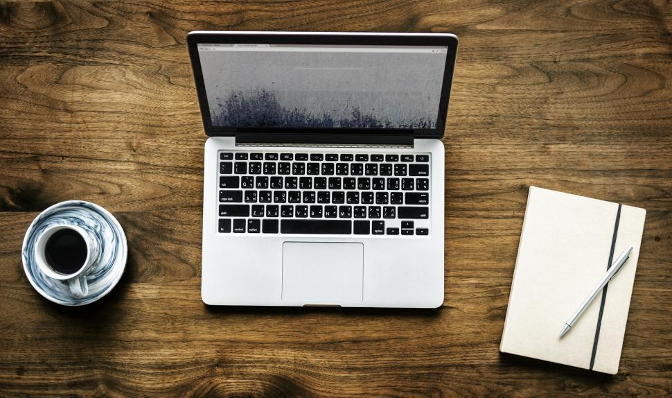 Free Image of Overhead view of a laptop on the table with dark wood grain 
