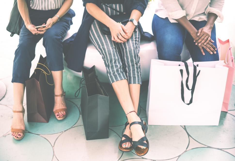 Free Image of A close up of legs and shopping bags in the city 