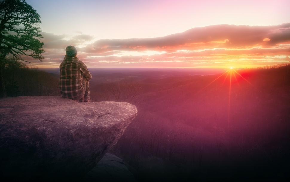 Free Image of Hiker Watching the Sunrise on Rock Ledge 