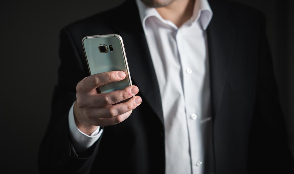 Free Image of Close up of a business person viewing his mobile phone 