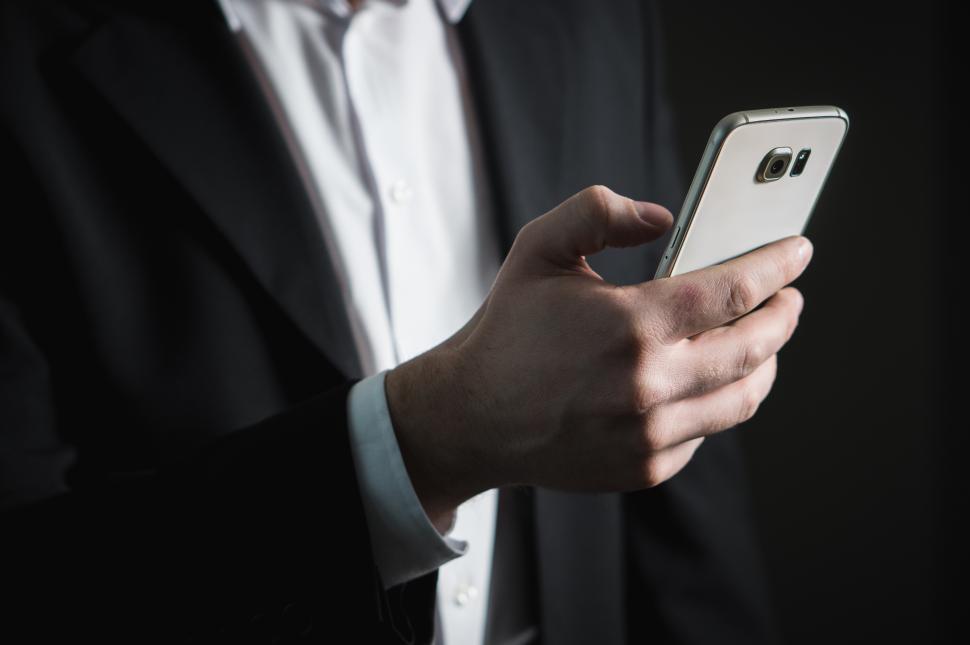 Free Image of Close up of a business person looking at mobile phone 