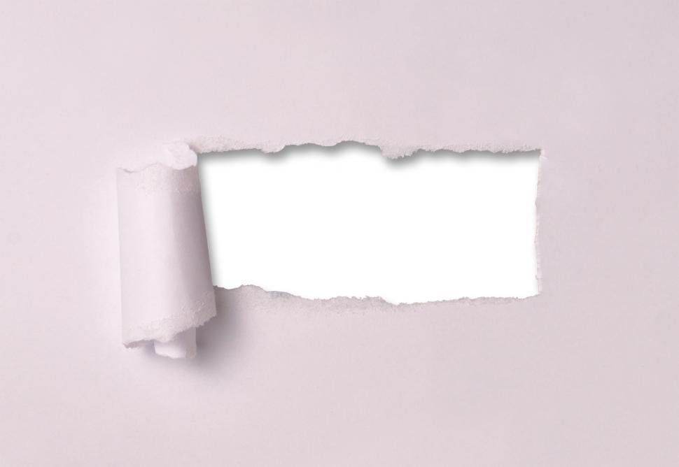 Free Image of A hole ripped through paper sheet with curled flap 