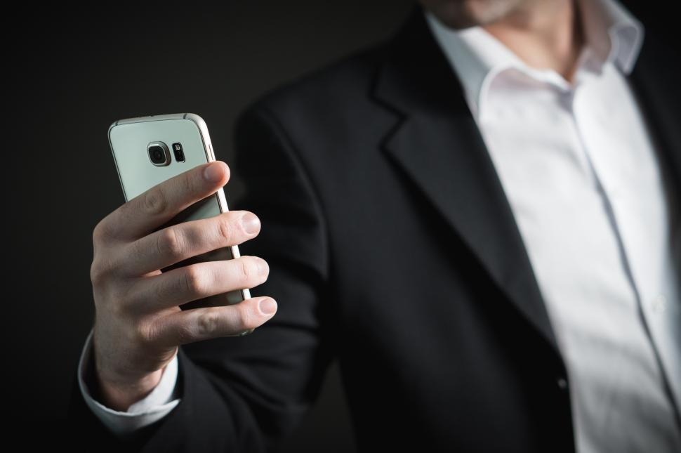 Free Image of Close up of a business person looking at mobile phone 