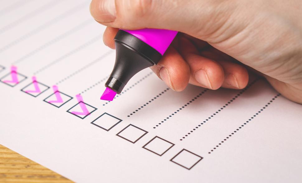 Free Image of Side view of a hand writing on a checklist with magenta marker 