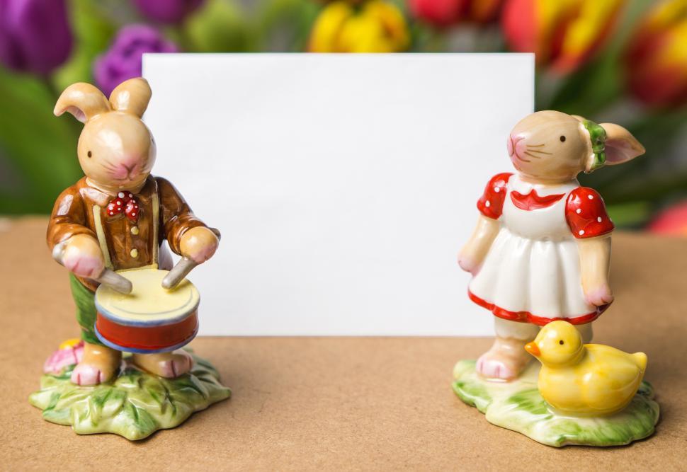 Free Image of Close up of ceramic Easter bunny rabbit toys with blank card 