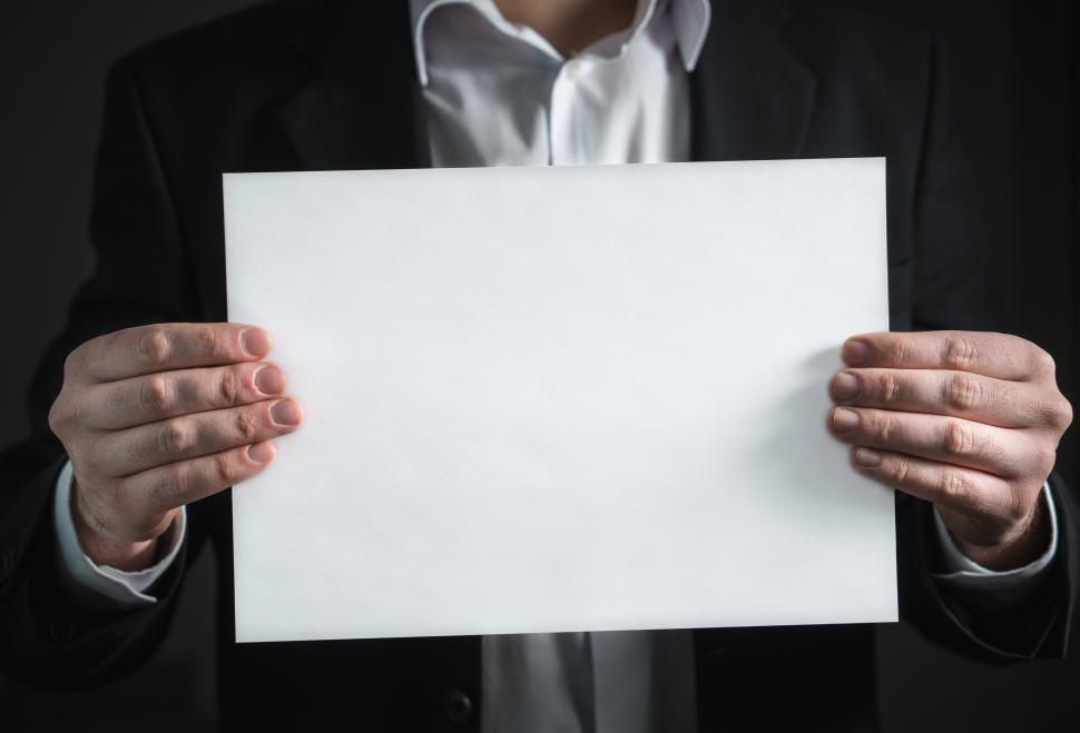 Free Image of A business person holding a blank sheet of paper 