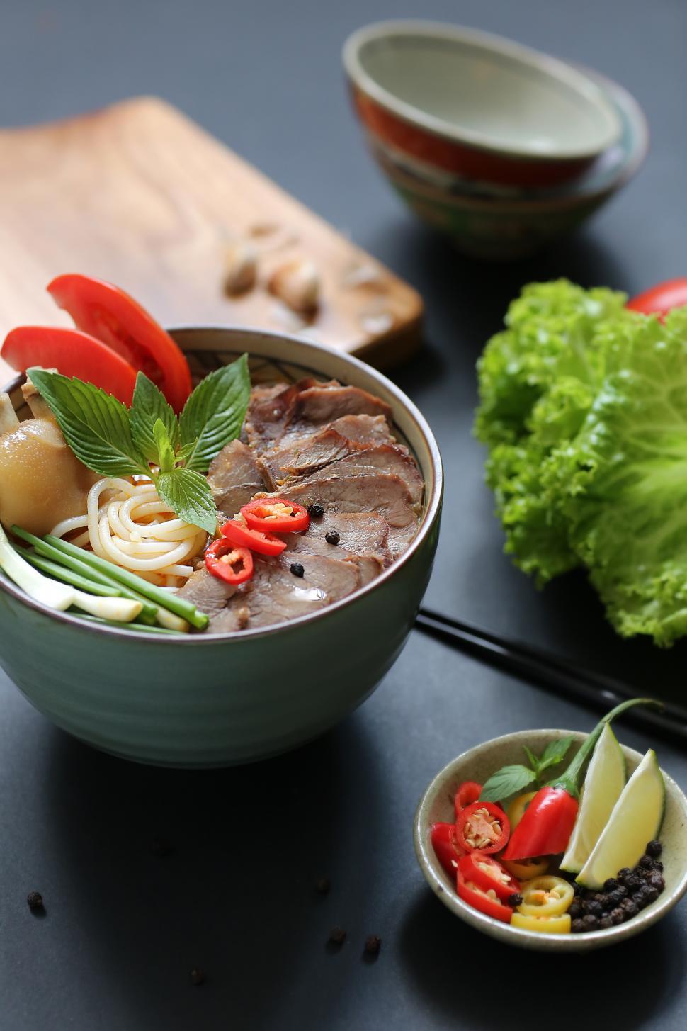 Free Image of Bowl of cooked noodles and fresh toppings 
