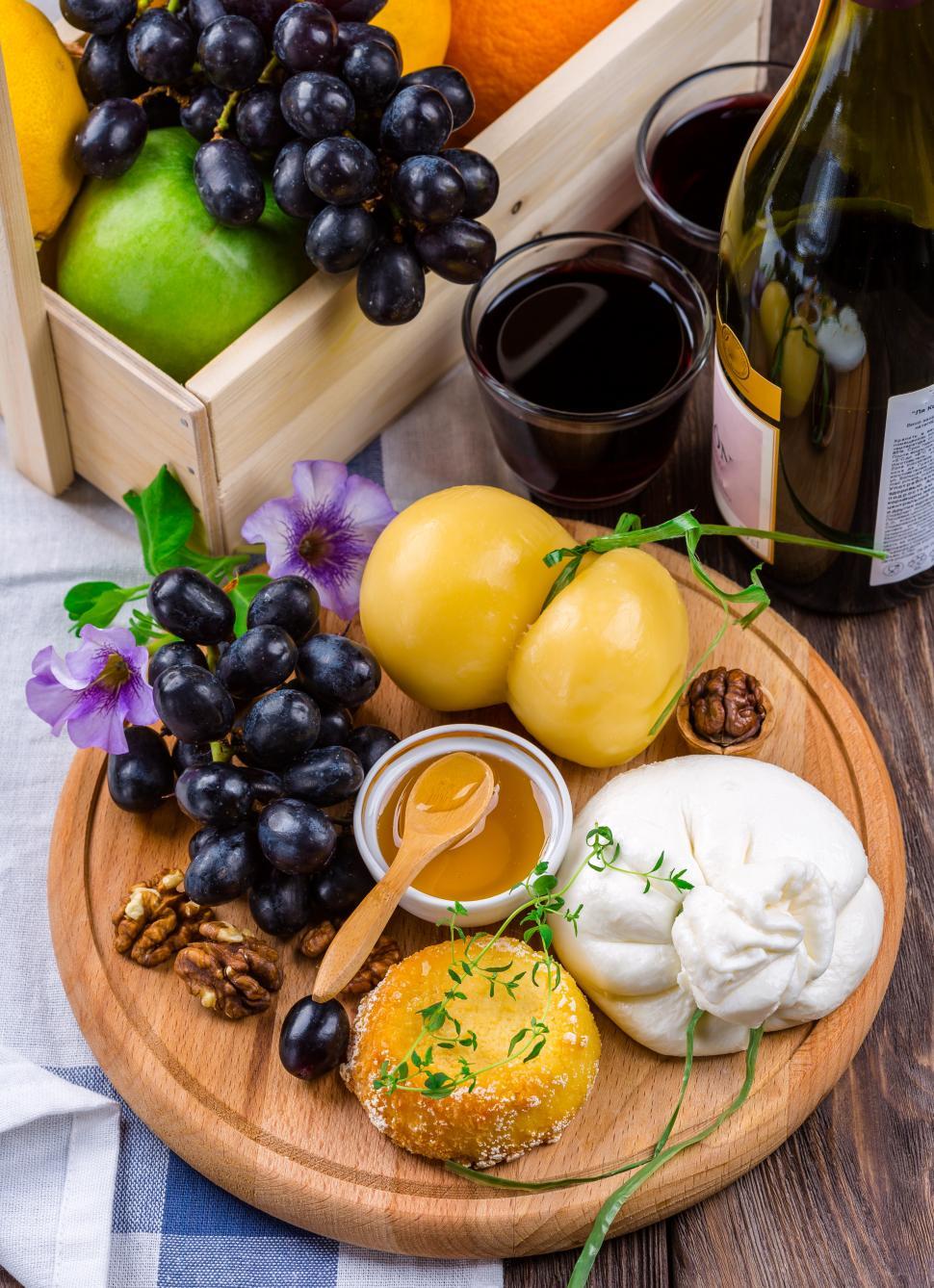 Free Image of Cheese Plate with black grapes on wooden board 