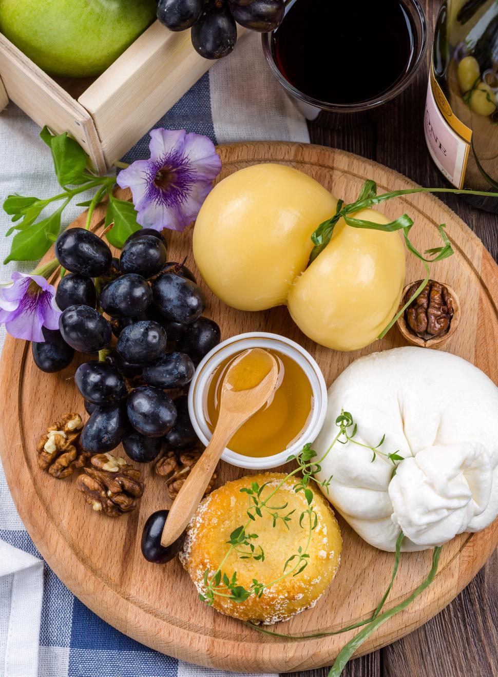 Free Image of Cheese and fruits on wooden board 