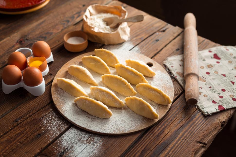 Free Image of Close up of table with Russian pirozhki baked patties ready to be baked 