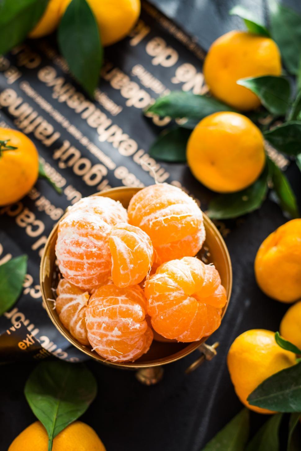 Free Image of overhead view of peeled mandarins in a brass fruit bowl 
