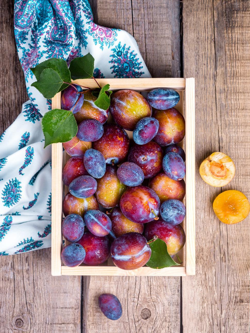Free Image of Overhead view of a crate full of ripe plums 