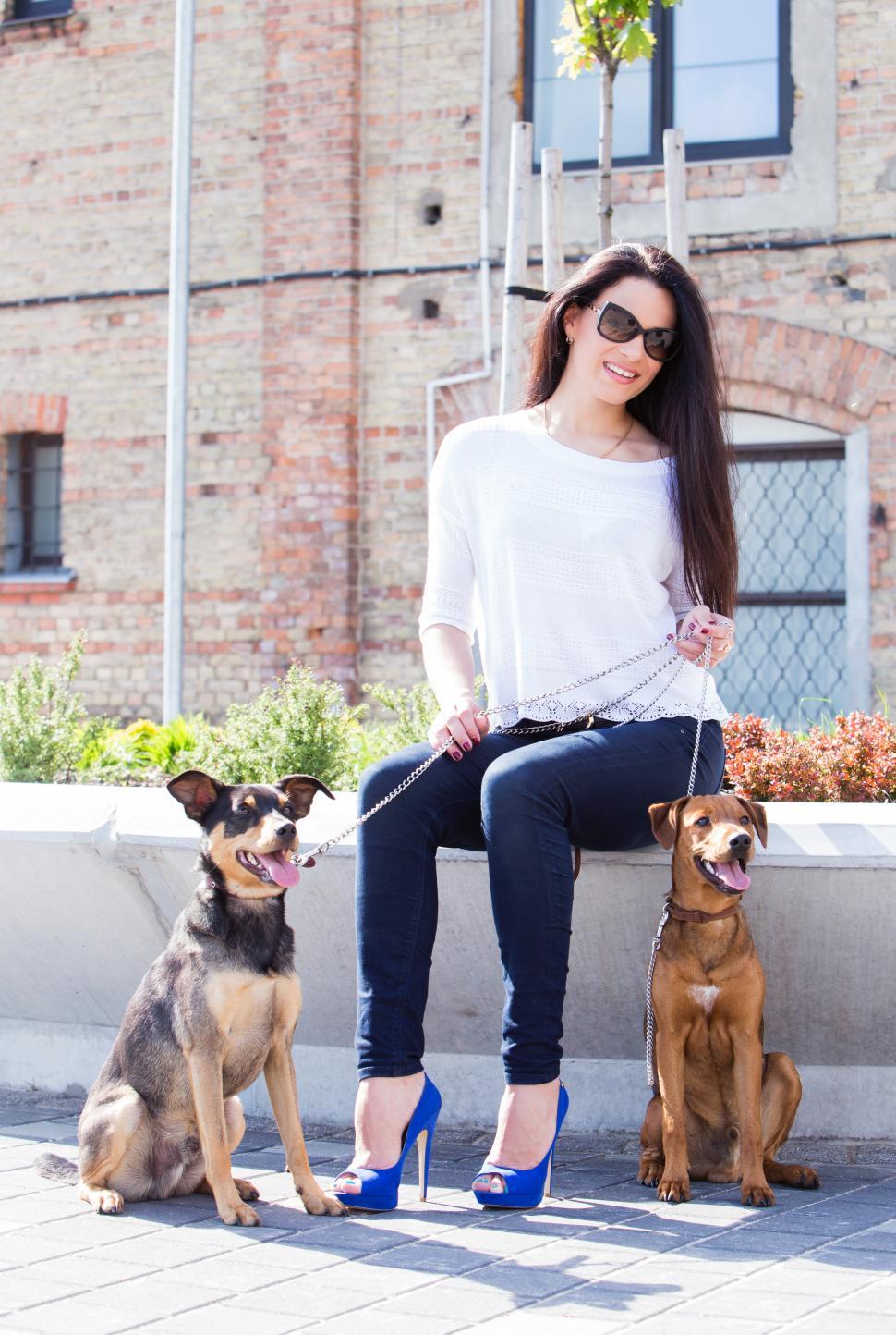 Free Image of Beautiful woman in city with dogs 
