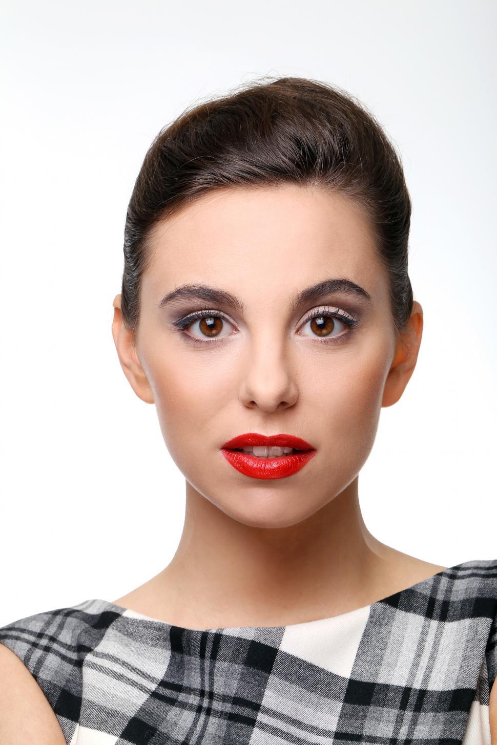 Free Image of Beautiful girl with perfect skin and red lipstick looking at camera 