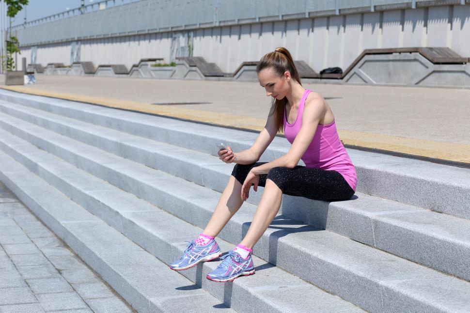 Free Image of Beautiful woman on the stairs with device 