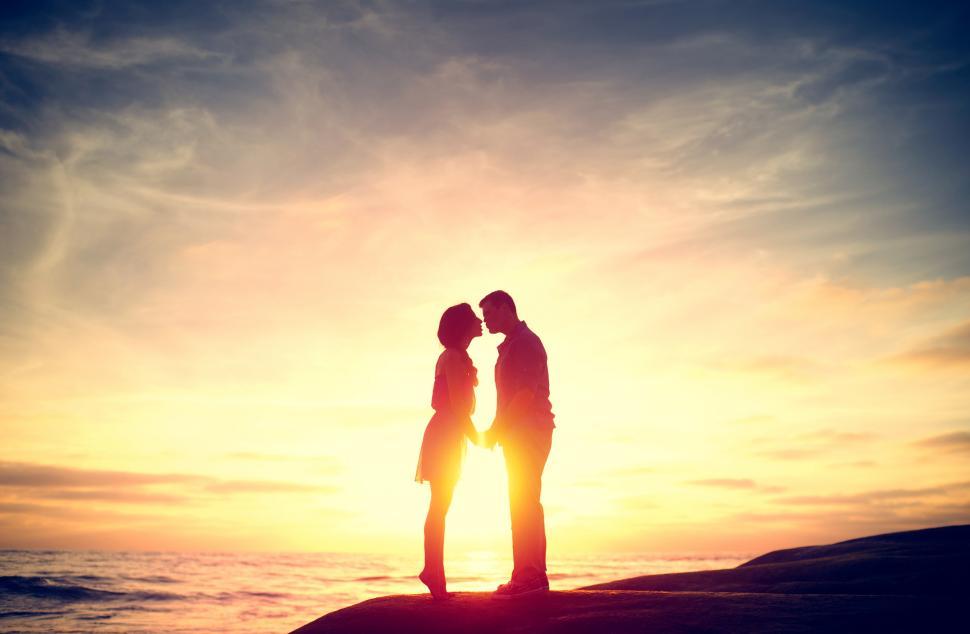 Free Image of Couple Kissing at Sunset on the Beach 
